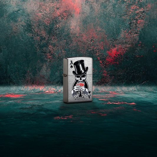 Lifestyle image of Zippo Rietveld Ace of Spades Design Street Chrome Windproof Lighter standing at a 3/4 angle showing the front and hinge side of the lighter with a dark gray and red graffiti background.