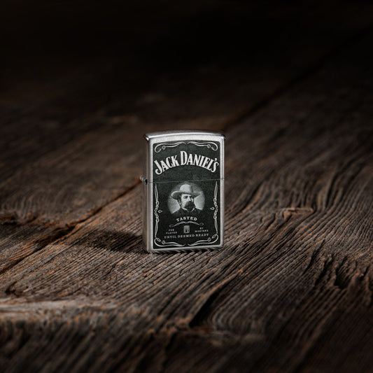 Lifestyle image of Zippo Jack Daniels Street Chrome Windproof Lighter standing on a wooden table.