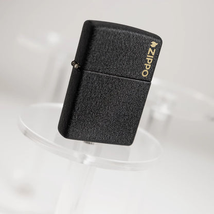 Lifestyle image of Zippo Classic Black CrackleÂ® Zippo Logo Windproof Lighter standing on a clear pedestal with the image at an angle.