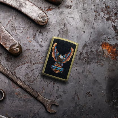 Lifestyle image of Zippo Harley-DavidsonÂ® Eagle Street Brass Windproof Lighter laying on a rusted and dented piece of metal with tools surrounding it.